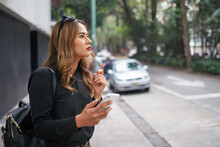 Attractive woman looking for a street address with gps and map on her device
