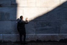 Man Against A Wall During A Sunny Day In Venice, Italy