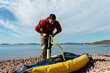 © Milles Studio/Stocksy - Focused man pumping boat before ride