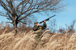 © Milles Studio/Stocksy - Huntsman shooting at birds near leafless tree