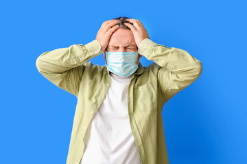 Sticker - Stressed mature man in medical mask on color background