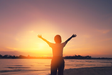 Wall Mural - Copy space of woman rise hand up on sunset sky at beach and island background.