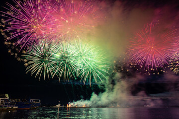 Wall Mural - Colorful fireworks reflect from water, beautiful scenery