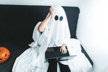 Confused ghost working on his computer on a halloween day