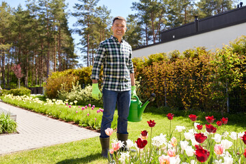 Sticker - gardening and people concept - happy smiling middle-aged man with watering can and flowers at garden