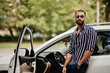 © AS Photo Family - Successful arab man wear in striped shirt and sunglasses pose near his white suv car. Stylish arabian men in transport.