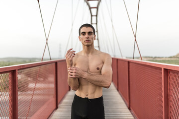 Wall Mural - Stretching man on pedestrian bridge portrait