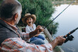 © cherryandbees - boy with his grandfather fishing on the lake
