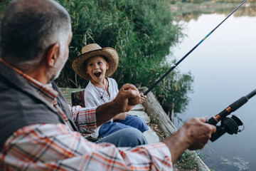 Wall Mural - boy with his grandfather fishing on the lake