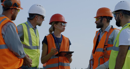 Female engineer speaking with male colleagues