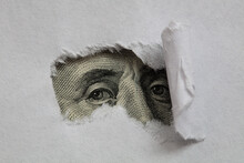 Benjamin Franklin Macro Peeking Through Torn White Paper