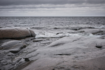 Wall Mural - wet cliffs in the foreground and the sea in the background, cloudy weather