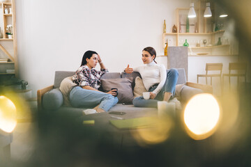 Best female friends talking on sofa