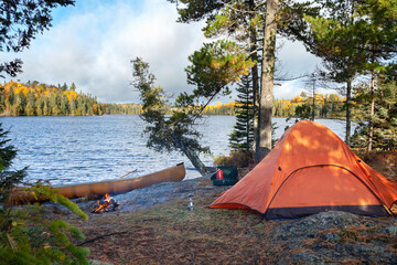 campsite with orange tent on northern minnesota lake during autumn
