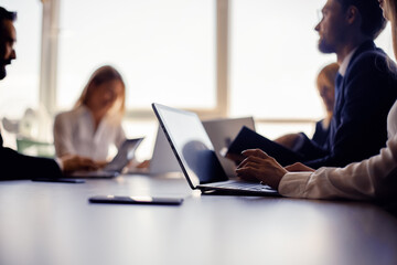 Office staff at work. Men and women sit at computers at the table. Blurred image. Toned image. High quality photo.