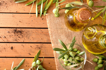 Wall Mural - Olive oil on table with branches and olives top view