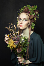 Halloween Character Woman With Creative Makeup, Flowers, Green Leaves And Tree Bark On Black