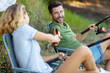 © auremar - woman and man having a beer while fishing lakeside