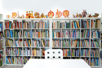 Russia Moscow 25.09.20 Children's city library. Special reading kids room with bright ceramic figures, toys. Many shelves, bright interesting, educational books about animals,fairy tales.Table, chair