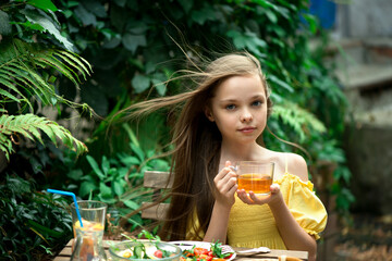 Cute little girl is drinking tea