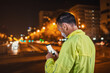 © MyMicrostock/Stocksy - Sportsman in yellow using mobile phone at night