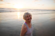 © Rob and Julia Campbell/Stocksy - Vibrant mature woman enjoying herself on the beach at sunset