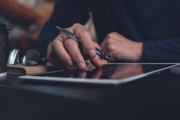 Close up of man hand zooming and reading E-book on digital tablet computer