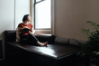 © Good Vibrations Images/Stocksy - Woman reading a book on a sofa