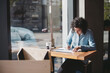 © Rob and Julia Campbell/Stocksy - Young woman drawing art in coffee shop