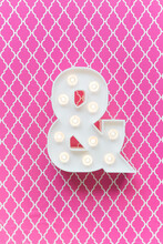 Ampersand Marquee Light On A Pink Background