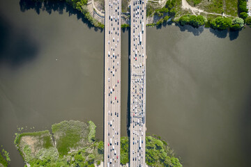 Cars driving through the bridge between two islands. Top down view from drone.