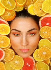 beautiful woman face around citrus fruits slices