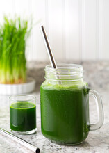Fresh Homemade Green Juice In A Glass Jar With Wheat Grass In The Background, Copy Space