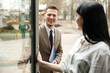 © Vlad - A man and a woman are smiling at each other. They are in the office building