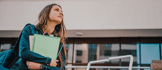 Back to school student teenager girl holding books and note books wearing backpack. Outdoor portrait of young teenager brunette girl with long hair. girl on city