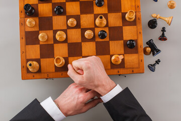 Wall Mural - Businessmans hand on chess board. Confident man in suit playing chess. Strategy, power and leadership concept.