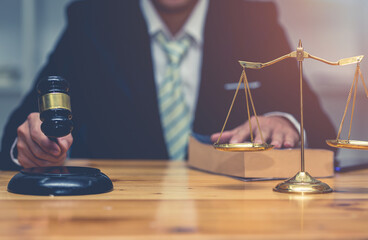 Attorney, Court judge,Legal and law concept image, A Male judge with client discussing about contract at courtroom on table.blurred lawyer working with laptop on background