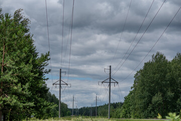 Power line in the forest against the background of clouds.