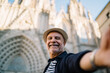 © BullRun - Cheerful man taking selfie against historical building