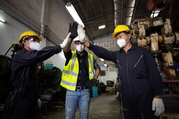 group of industrial technician worker giving high five or raise hands for success the project together in factory, new normal concept