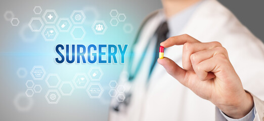 Close-up of a doctor giving you a pill with SURGERY inscription, medical concept