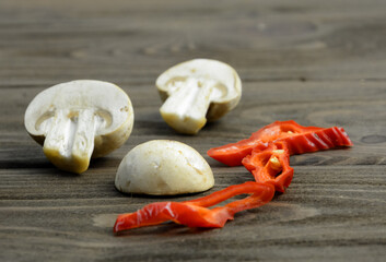 Champignons and hot red peppers on a wooden table.