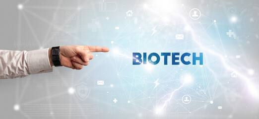 Hand pointing at BIOTECH inscription, modern technology concept