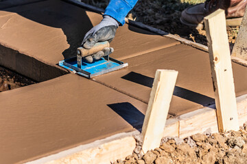 Wall Mural - Construction Worker Using Hand Groover On Wet Cement Forming Coping Around New Pool