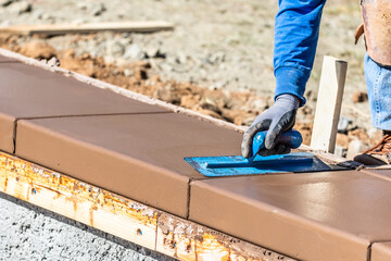 Wall Mural - Construction Worker Using Trowel On Wet Cement Forming Coping Around New Pool