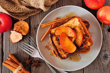 Wall Mural - Caramel apple cinnamon french toast. Overhead view table scene on a dark wood background. Fall breakfast concept.