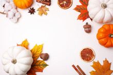 Autumn Frame With Decorative Pumpkins And Autumn Leaves On A White Background. Flat Lay Style