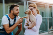 © hedgehog94 - Young handsome worker helping a young women to adopt beautiful dog.