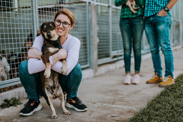 Wall Mural - Young nice looking couple wants to adopt beautiful dog at animal shelter.