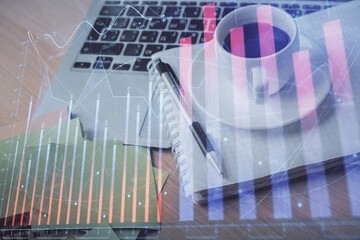 Double exposure of forex chart drawing and desktop with coffee and items on table background. Concept of financial market trading